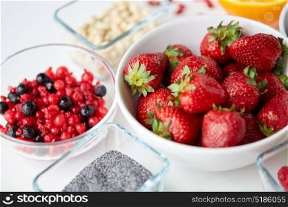 healthy eating and food concept - fruits and berries in bowls on table. fruits and berries in bowls on table