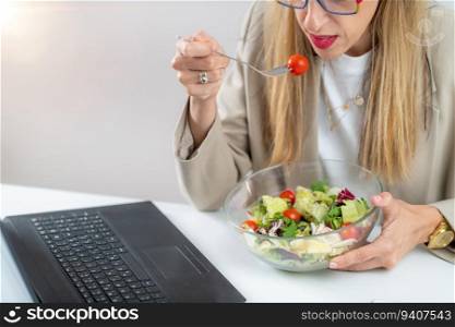 Healthy eating at work. Woman indulges in a delightful fresh salad at her workplace. With every bite, she embraces the nourishing flavors and invigorating energy of her nutritious meal, fueling her day with a refreshing and health-conscious choice. Woman Eating Fresh Salad at Workplace