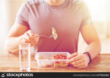 healthy eating, balanced diet, food and people concept - close up of male hands having meat and vegetables for dinner with fork and water glass