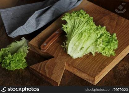 Healthy eating concept. Raw green organic lettuce ready to chop on cutting board with knife.. Healthy eating concept. Raw green organic lettuce ready to chop on cutting board with knife