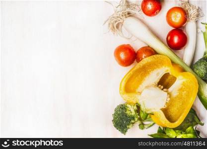 Healthy eating concept with colorful vegetables on white wooden background, top view, border