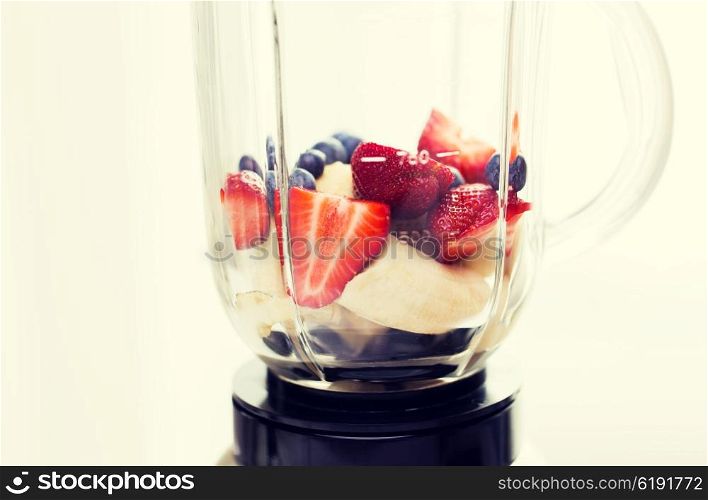 healthy eating, cooking, kitchen appliances and technology concept - close up of blender shaker with fruits and berries