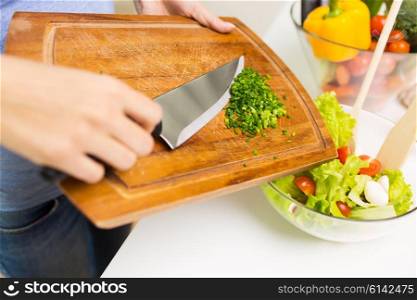 healthy eating, cooking, vegetarian food, diet and people concept - close up of woman adding chopped green onion to salad