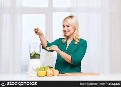 healthy eating, cooking, vegetarian food, diet and people concept - smiling young woman putting fruits and vegetables into blender at home kitchen