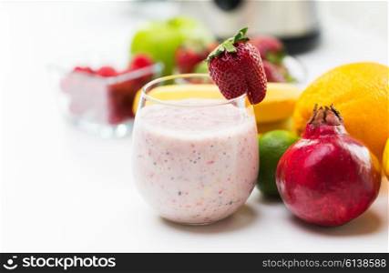 healthy eating, cooking, vegetarian food, dieting and people concept - close up of glass with strawberry milk shake and fruits
