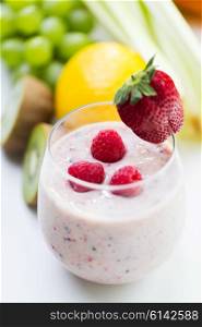healthy eating, cooking, vegetarian food, dieting and people concept - close up of glass with strawberry milk shake and fruits