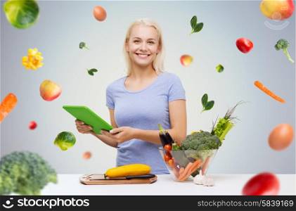 healthy eating, cooking, vegetarian food, technology and people concept - smiling young woman with tablet pc computer and bowl of vegetables over gray background with falling vegetables
