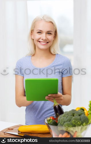 healthy eating, cooking, vegetarian food, technology and people concept - smiling young woman with tablet pc computer and bowl of vegetables at home