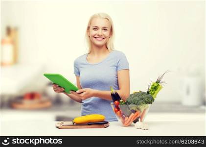 healthy eating, cooking, vegetarian food, technology and people concept - smiling young woman with tablet pc computer and bowl of vegetables over home kitchen background