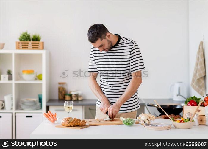 healthy eating, culinary and people concept - happy man cooking food at home kitchen. man cooking food at home kitchen