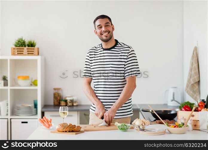 healthy eating, culinary and people concept - happy man cooking food at home kitchen. man cooking food at home kitchen