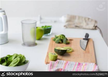 healthy eating, diet and cooking concept - green fruits and vegetables on kitchen table. green fruits and vegetables on kitchen table