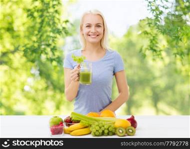 healthy eating, diet and detox concept - smiling woman drinking vegetable juice or fresh with celery from glass over green natural background. woman drinking green juice or fresh with celery