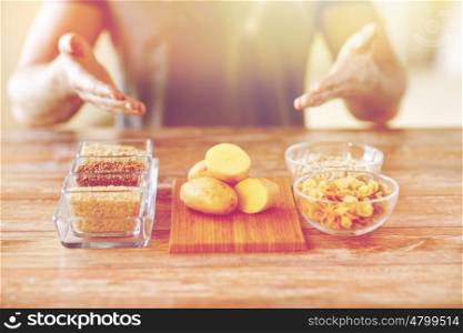 healthy eating, diet and people concept - close up of male hands showing carbohydrate food on table
