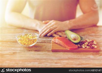 healthy eating, diet and people concept - close up of male hands with food rich in protein on cutting board on table