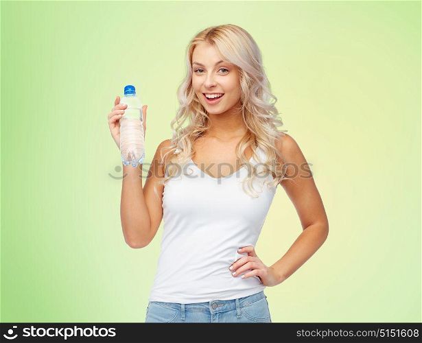 healthy eating, diet and people concept - happy beautiful young woman holding bottle of water over green background. happy beautiful young woman with bottle of water