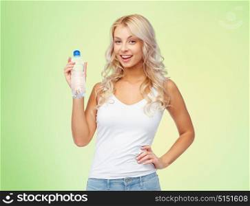 healthy eating, diet and people concept - happy beautiful young woman holding bottle of water over green background. happy beautiful young woman with bottle of water