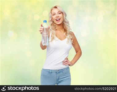 healthy eating, diet and people concept - happy beautiful young woman holding bottle of water over summer green lights background. happy beautiful young woman with bottle of water