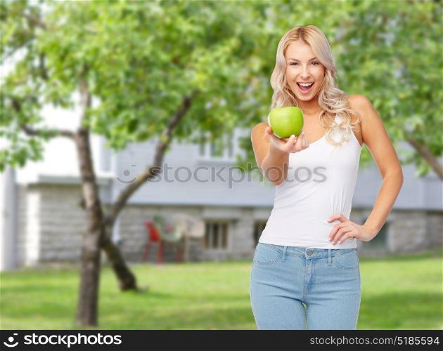 healthy eating, diet and people concept - happy beautiful young woman with green apple over summer garden background. happy beautiful young woman with green apple