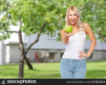 healthy eating, diet and people concept - happy beautiful young woman with green apple over summer garden background. happy beautiful young woman with green apple