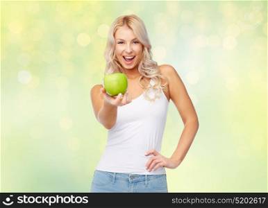 healthy eating, diet and people concept - happy beautiful young woman with apple over summer green lights background. happy beautiful young woman with green apple