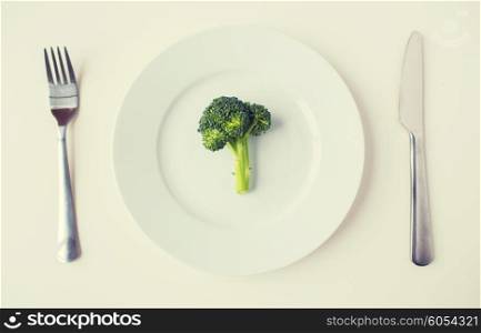 healthy eating, diet, vegetarian food and culinary concept - close up of broccoli on plate