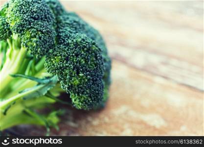 healthy eating, diet, vegetarian food and culinary concept - close up of broccoli on wooden table