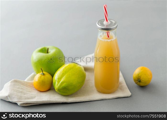 healthy eating, dieting and eco friendly concept - reusable glass bottle of fruit juice with straw. reusable glass bottle of fruit juice with straw