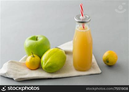 healthy eating, dieting and eco friendly concept - reusable glass bottle of fruit juice with straw. reusable glass bottle of fruit juice with straw