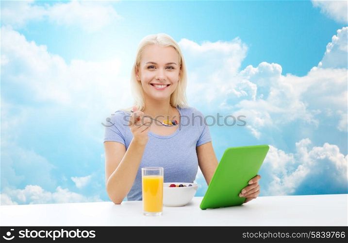 healthy eating, dieting and people concept - smiling young woman with tablet pc computer eating breakfast over blue sky and clouds background