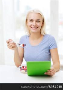 healthy eating, dieting and people concept - smiling young woman with tablet pc computer eating fruit salad at home