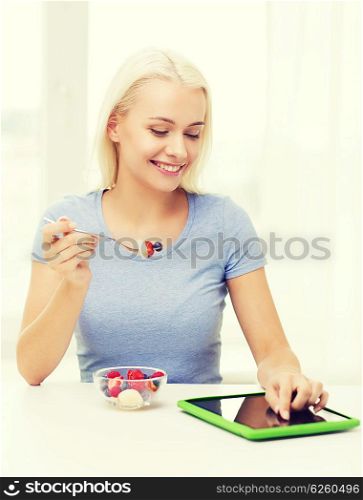 healthy eating, dieting and people concept - smiling young woman with tablet pc computer eating fruit salad at home