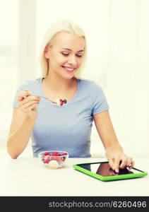 healthy eating, dieting and people concept - smiling young woman with tablet pc computer eating fruit salad at home