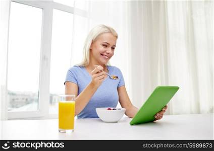 healthy eating, dieting, technology and people concept - smiling young woman with tablet pc computer eating breakfast at home
