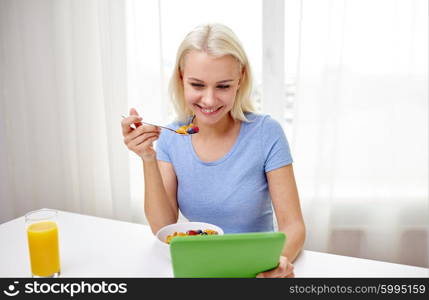 healthy eating, dieting, technology and people concept - smiling young woman with tablet pc computer eating breakfast at home