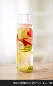healthy eating, drinks and detox concept - close up of fruit water or ice tea in glass bottle. close up of fruit water in glass bottle