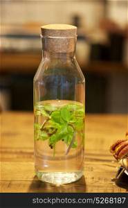 healthy eating, drinks and detox concept - fruit water with peppermint in glass bottle. fruit water with peppermint in glass bottle