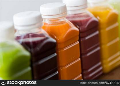 healthy eating, drinks, diet and detox concept - close up of plastic bottles with different fruit or vegetable juices