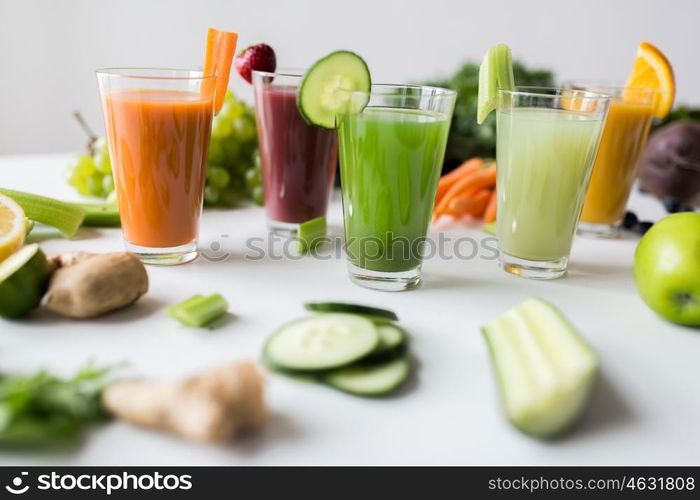 healthy eating, drinks, diet and detox concept - glasses with different fruit or vegetable juices and food on table