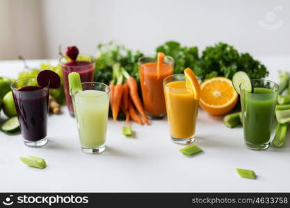 healthy eating, drinks, diet and detox concept - glasses with different fruit or vegetable juices and food on table