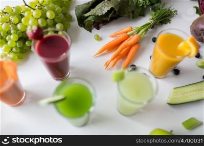 healthy eating, drinks, diet and detox concept - glasses with different fruit or vegetable juices and food on table
