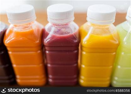 healthy eating, drinks, dieting and packaging concept - close up of plastic bottles with different fruit or vegetable juices