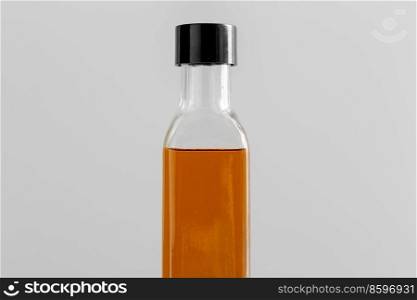 healthy eating, food and culinary concept - close up of olive oil in glass bottle on grey background. close up of olive oil in glass bottle