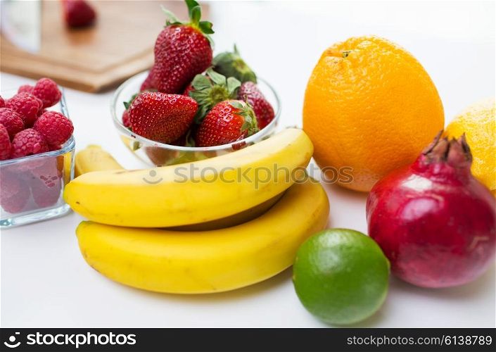 healthy eating, food and diet concept- close up of fresh ripe fruits and berries on table