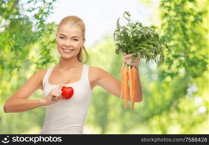 healthy eating, food and diet concept - happy smiling young woman holding red heart and carrots over green natural background. happy smiling young woman with heart and carrots
