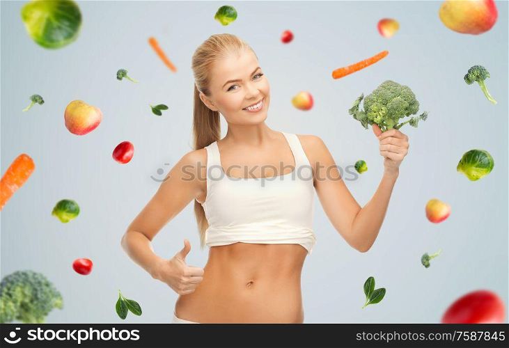 healthy eating, food and diet concept - happy smiling young woman holding broccoli. happy smiling young woman with broccoli
