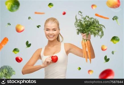 healthy eating, food and diet concept - happy smiling young woman holding red heart and carrots. happy smiling young woman with heart and carrots