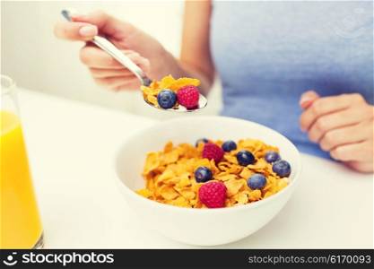 healthy eating, food and people concept - close up of woman eating corn flakes for breakfast at home