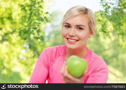 healthy eating, food, diet and people concept - happy smiling woman with green apple over natural background. happy woman with green apple