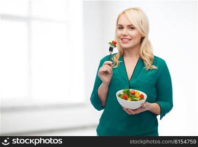 healthy eating, food, diet and people concept - smiling young woman eating vegetable salad with fork over white room background